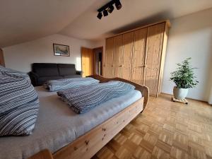 een slaapkamer met een groot bed en een potplant bij Ferienwohnung-Felisa in Peterswörth