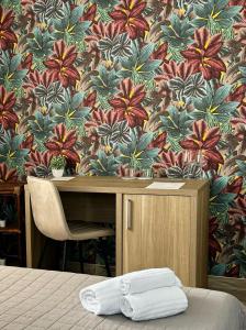 a bedroom with a desk with a flower wallpaper at B&B Sun Of Sicily in Noto