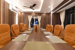 KalyaniN B Sonar Bangla Hotel的有一张长桌和椅子的会议室