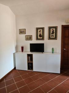 a living room with a white entertainment center with a television at Arbatax, 200 metres from the beach: Apartment in villa with garden, 2 bedrooms in Àrbatax