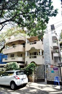 a silver car parked in front of a building at SAS Apartment in Bangalore