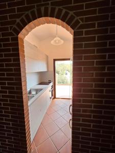 an archway in a kitchen with a brick wall at Arbatax, 200 metres from the beach: Apartment in villa with garden, 2 bedrooms in Àrbatax