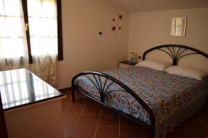 a bedroom with a bed and a window at Arbatax, 200 metres from the beach: Apartment in villa with garden, 2 bedrooms in Àrbatax +5 photos