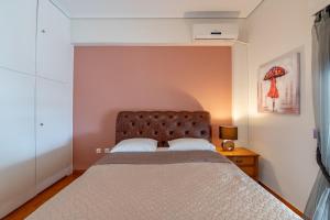 una camera con letto e testiera marrone di Marina Zeas Classyhub a Pireo