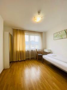 een kamer met een bed, een bureau en een raam bij Apartamente Pfullingen in Pfullingen