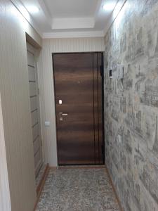 a hallway with a wooden door and a stone wall at Sayat-Nova Apartments Yerevan in Yerevan