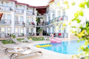a hotel with a pool and a pink flamingos in a courtyard at Akın Apart and Hotel in Antalya