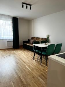 uma sala de estar com uma mesa e um sofá em Apartament na Orkana em Rabka-Zdroj