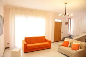 a living room with an orange chair and a couch at Dream on the Blue House in Valderice