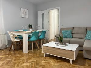 a living room with a table and a couch at VuT Las Almenas in Ávila