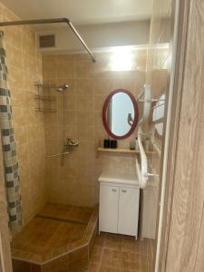 een badkamer met een douche, een spiegel en een wastafel bij White apartment in Kėdainiai