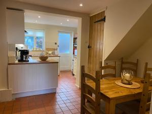 a kitchen and dining room with a wooden table at A charming and stylish country cottage. in Hungerford