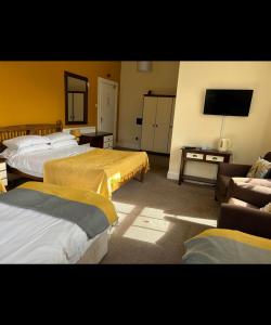 um quarto de hotel com duas camas e uma televisão de ecrã plano em Bonny Moor Hen em Stanhope