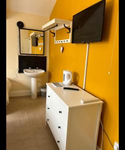 a bathroom with a sink and a desk with a monitor on the wall at Bonny Moor Hen in Stanhope