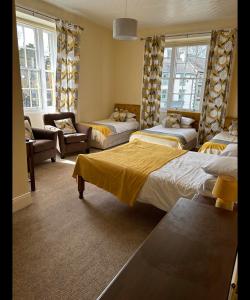 a room with three beds and a living room with a couch at Bonny Moor Hen in Stanhope