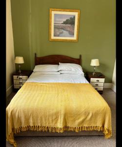 a bedroom with a bed with a yellow blanket on it at Bonny Moor Hen in Stanhope