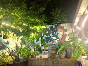 une fresque d'un singe sur un mur avec des plantes dans l'établissement Vang Vieng Lily Guesthouse, à Vang Vieng