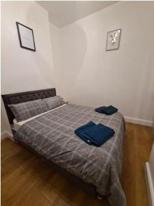 Lovely luxury one bedroom flat في لندن: غرفة نوم عليها سرير وفوط زرقاء