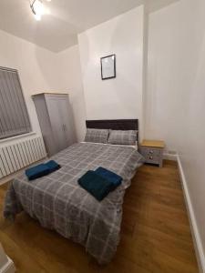um quarto com uma cama com duas almofadas azuis em Lovely luxury one bedroom flat em Londres