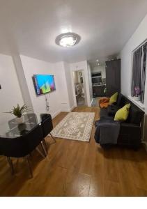a living room with a couch and a glass table at Lovely luxury one bedroom flat in London