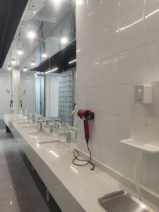 a public bathroom with a row of sinks and a phone at WeFlow Youth Hostel - Shanghai People's Square Jing'an Joy City in Shanghai