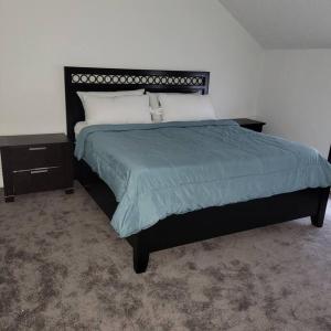 ein Schlafzimmer mit einem großen Bett mit einer blauen Decke in der Unterkunft Entire house - 4 Bedroom-Enfield in Enfield