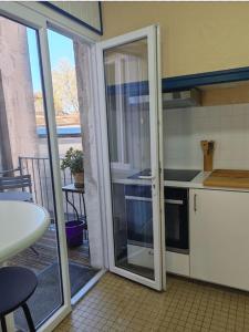 d'une cuisine avec une porte coulissante en verre s'ouvrant sur un balcon. dans l'établissement Apartment With Balcony In The City Of Avignon, à Avignon