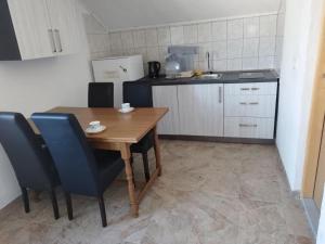 a small kitchen with a wooden table and chairs at Villa Behar in Gnojnice
