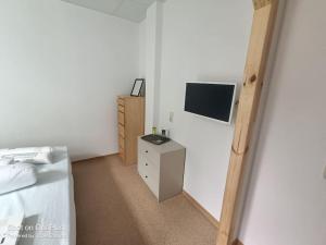 a bedroom with a bed and a tv on a wall at FEWO an der ZWÄNS in Stollberg