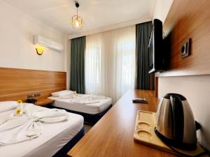 a hotel room with two beds and a television at Akın Apart and Hotel in Antalya