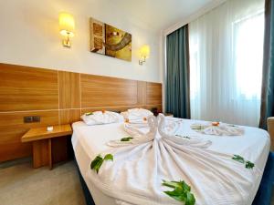 a hotel room with a bed with white sheets at Akın Apart and Hotel in Antalya +22 photos
