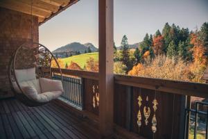 a porch with a chair and a view of the mountains at Ruhehotel & Naturresort Rehbach - Adults only in Schattwald