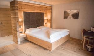 ein Schlafzimmer mit einem großen Bett in einem Zimmer in der Unterkunft Ruhehotel & Naturresort Rehbach - Adults only in Schattwald
