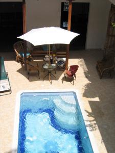 una piscina azul con mesa y sillas en Hotel Casa Belle Epoque, en Honda
