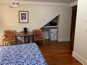 a bedroom with a bed and a table and chairs at Broadway guest house in Vancouver