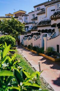 a row of white buildings with plants in the foreground at Casa Costa del Sol Beach&Golf,Marbella in Sitio de Calahonda
