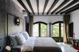 a bedroom with a large bed and a large window at Finca Legado Ibiza in Santa Eularia des Riu