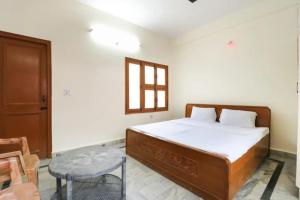a bedroom with a bed and a table and a window at Hotel Bhameshwari Haridwar Near Bharat Mata Mandir - Prime Location - Excellent Service in Haridwār