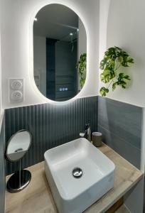 y baño con lavabo blanco y espejo. en Le Palmae, appartement cosy, cœur de ville, climatisé, en Hyères