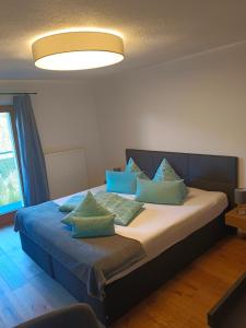 a bedroom with a bed with blue pillows at Haus Berghof in Gries am Brenner