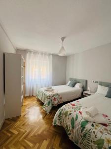 um quarto de hotel com duas camas e uma janela em VuT Las Almenas em Ávila