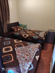ein Zimmer mit drei Betten in einem Zimmer in der Unterkunft شاليه في بورتو مارينا in El-Alamein