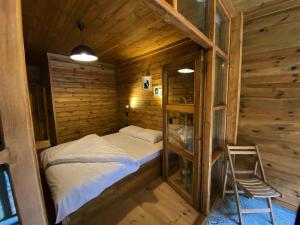 a small bedroom with a bed in a wooden cabin at Moi in Rize