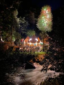 a house lit up with christmas lights next to a river at Moi in Rize