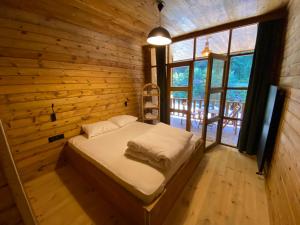 a bed in a room with a wooden wall at Moi in Rize