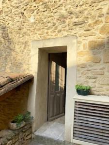 una porta per un edificio in pietra con due piante in vaso di Maison de village panoramique a Châteauneuf-du-Pape