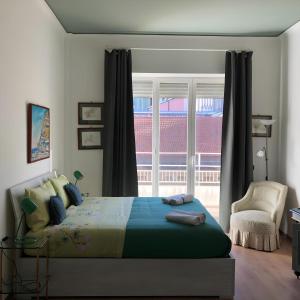 um quarto com uma cama, uma janela e uma cadeira em LGM Charming Apartment em Nápoles