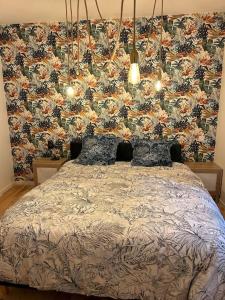 Schlafzimmer mit einem Bett mit Blumentapete in der Unterkunft Le floral in Carcassonne