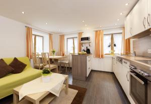 a kitchen and living room with a couch and a table at Roslerhof in Inzing