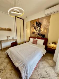 a bedroom with a large bed with a painting on the wall at City lux apartment 1 in Serres